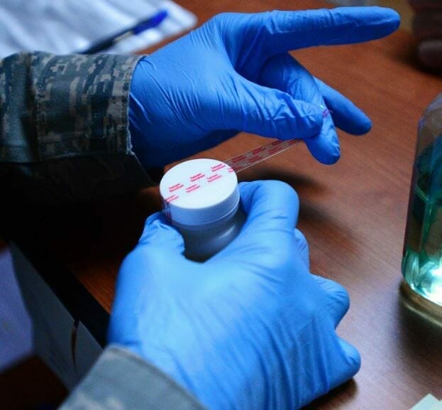 hand with gloves that is mixing a bottle