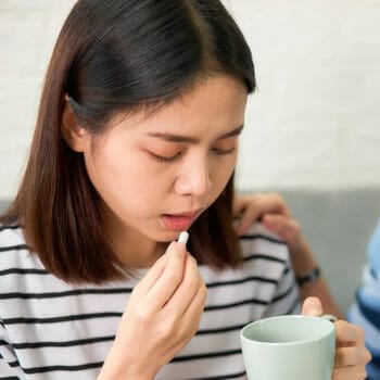An Asian adult taking niacin pills to pass a drug test