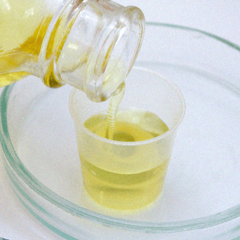 Synthetic urine pouring out from a bottle to a small container