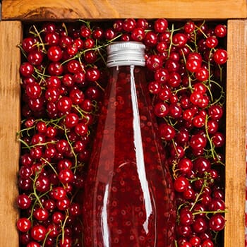 Cranberry juice on a box full of cranberries
