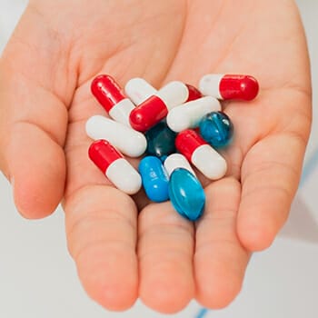 Hand holding numerous a number of pills