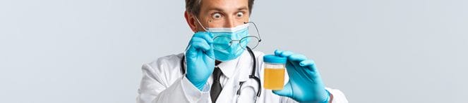 Startled doctor looking at urine sample