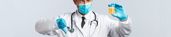 Doctor giving a thumbs down to a urine sample