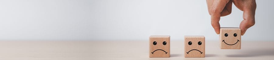 wood blocks with sad and happy faces