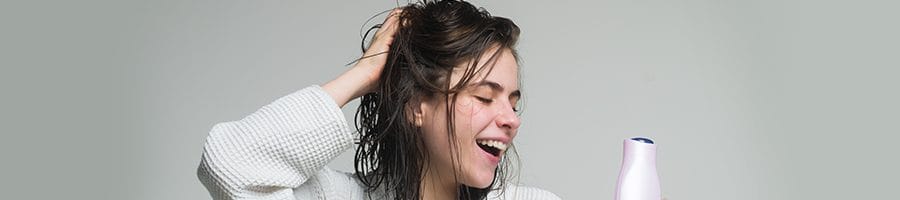 female smiling while touching head