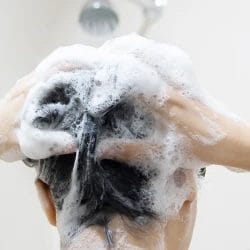 Woman cleaning her hair with shampoo