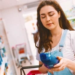 Woman looking at shampoo inside store