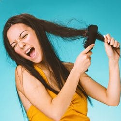 Woman brushing hair ineffectively