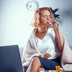 A woman sitting while drinking water