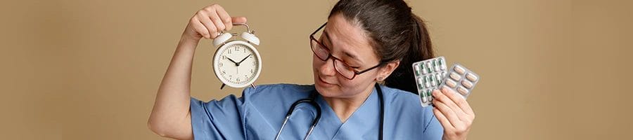 A nurse holding a clock and medicines