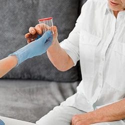 A doctor handing over a urine jar to a patient