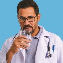 A doctor drinking a glass of detox