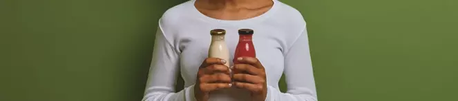 A woman holding two detox drinks