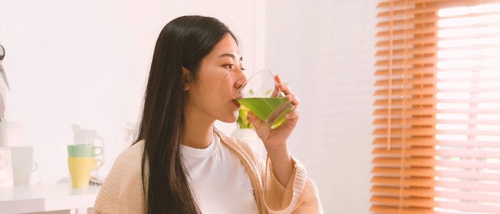 A woman drinking a detox drink to flush out meth