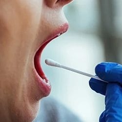 A close up shot of a doctor getting a saliva sample