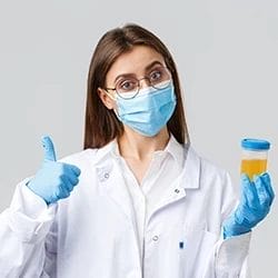 A doctor holding a jar of urine and doing a thumbs up