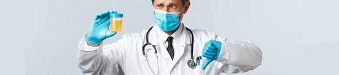 A doctor holding a urine sample while showing a thumbs down